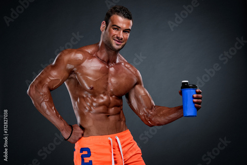 Nutritional Supplement. Muscular Men Drinks Protein, Energy Drink After Workout. Copy Space