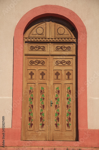 Decorated wood door on the facade of Chapel