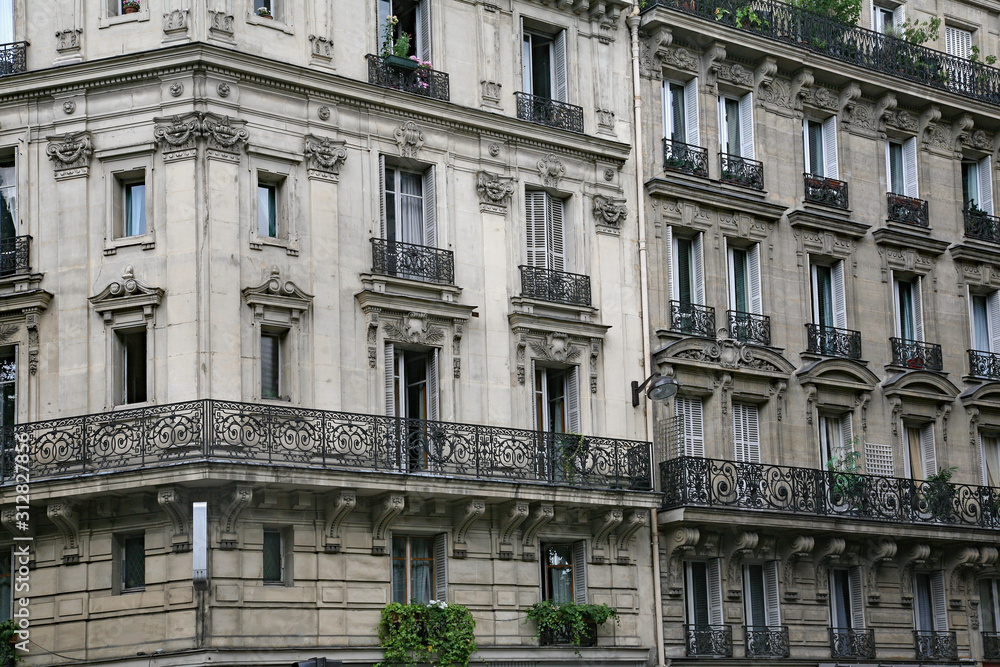 Paris, typical old apartment building with wrought iron balcony railings and planters.