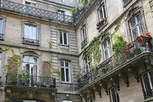 Canvas Print Paris, typical old apartment building with wrought iron balcony railings and planters