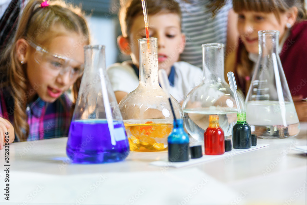 Test tubes with colorful liquid substances. Study of liquid states. Group school pupils with test tubes study chemical liquids. Science concept. Girls and boy providing experiment with liquids. Test tubes with colorful liquid substances. Study of liquid states. Group school pupils with test tubes study chemical liquids. Science concept. Girls and boy providing experiment with liquids.