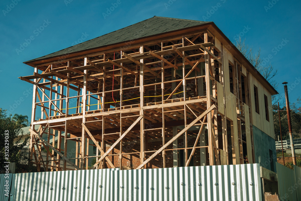 Construction site with wooden house being built Construction site with wooden house being built