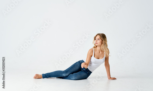 young woman sitting on the floor isolated on white