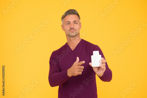 Helping to make better shopping decision. Handsome man point finger at bottle. Advertising product. Advertising perfume. Advertisement. Promoting and advertising. Fragrance advertising, copy space