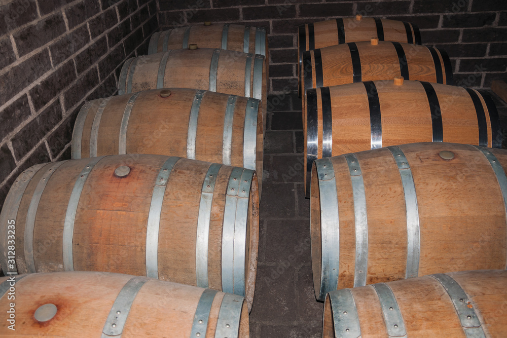 Wooden barrels for wine storage in a cellar Wooden barrels for wine storage in a cellar