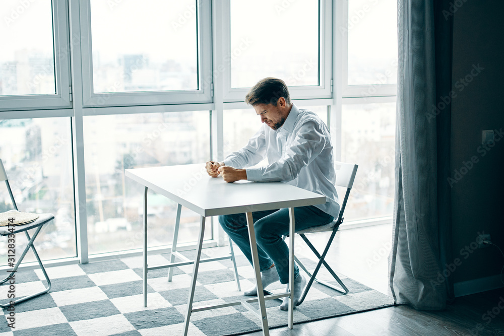 man sitting on chair in front of window man sitting on chair in front of window