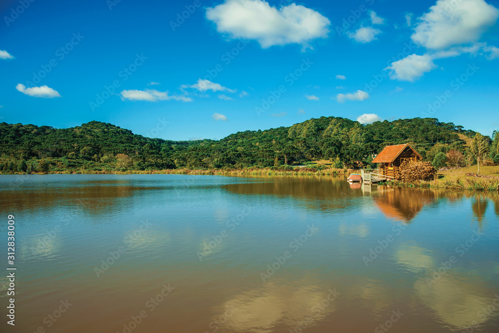 Small rustic shack reflected on the lakeside