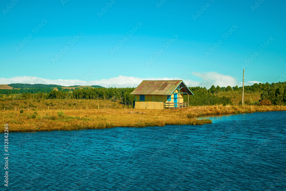 Wooden chalet facing a blue water lake Wooden chalet facing a blue water lake