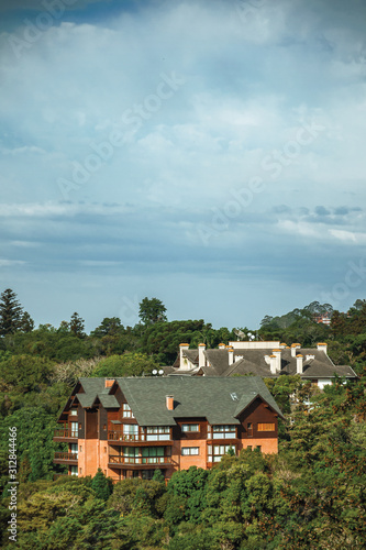 Townhouses on top of hill covered by lush forest