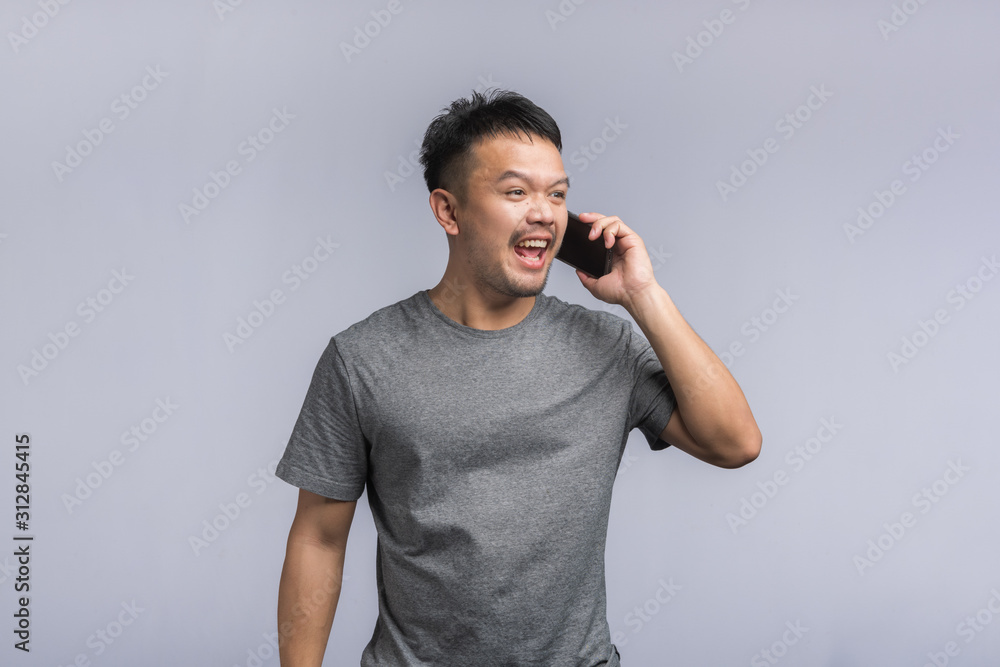 good looking Asian man talking on the phone, getting goods news,excited happy. good looking Asian man talking on the phone, getting goods news,excited happy.