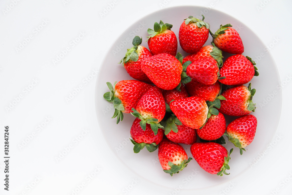 Fresh strawberries on a light grey plate, on a white background Fresh strawberries on a light grey plate, on a white background
