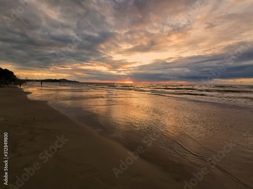Fototapeta Naklejka Na Ścianę i Meble -  Dramatic clouds during sunset on the beach.