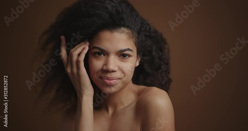 Portrate of nude african american girl gently touching her perfect skin face photo