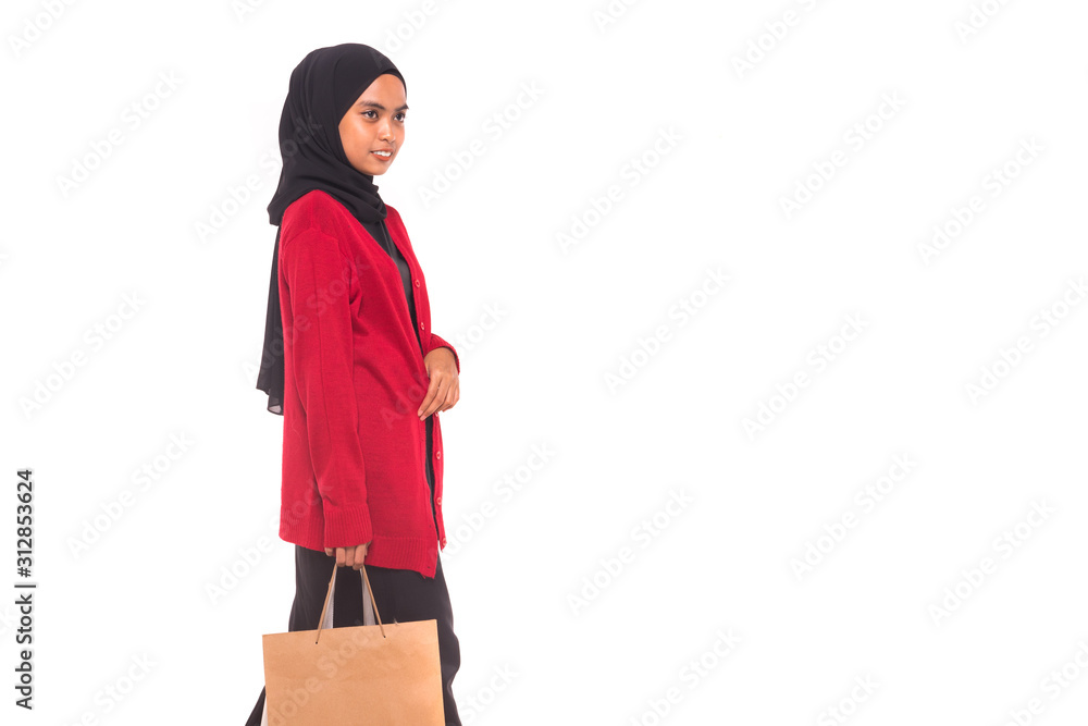 Happy young Muslim girl holding shopping bags isolated over white background. Happy young Muslim girl holding shopping bags isolated over white background.