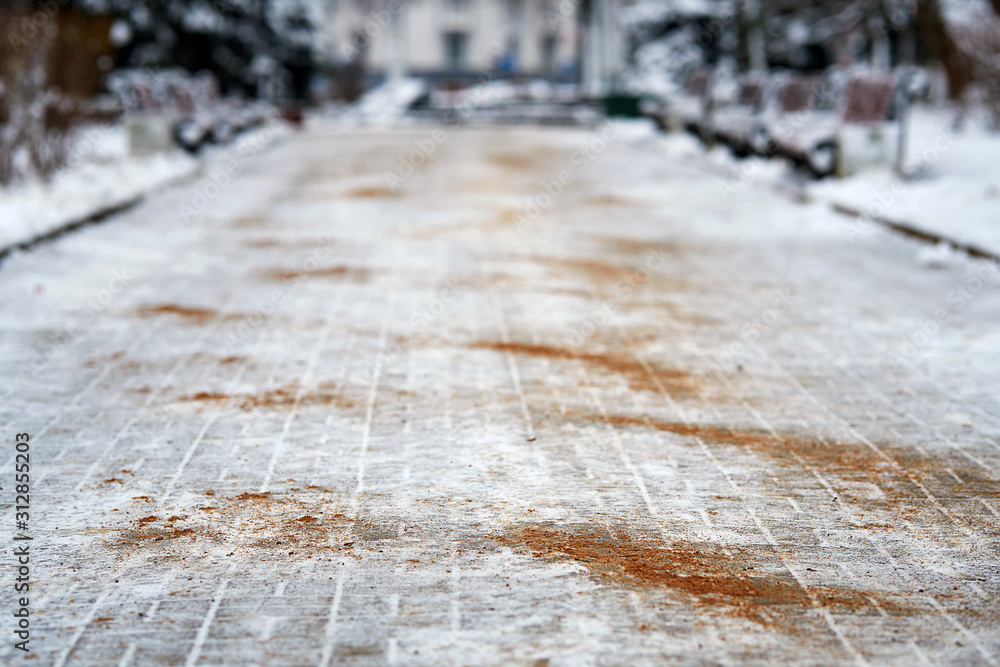 Walkway sprinkled with salt mixtures and sand. Deicing chemicals on pavement. Prevent slipping