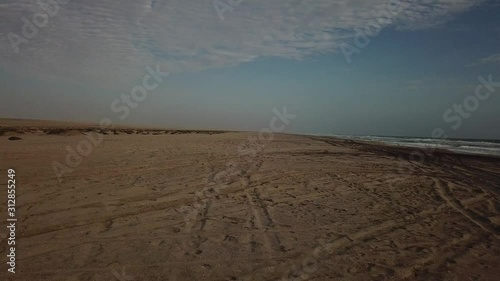 4K aerial drone video view of Namibian Atlantic coastline, Zeila L-758 Walvis Bay stranded rusty shipwreck at sand beach in Skeleton Coast Park landscape with ocean background at Namibia's west coast photo