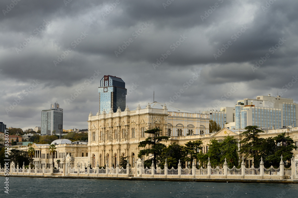 Facade of Dolmabahce Palace surrounded by modern buildings on the Bosphorus Strait Istanbul