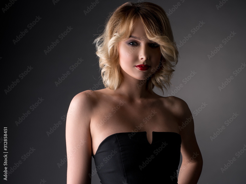 Naklejka premium Pretty blonde dressed in black cocktail dress
