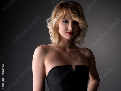 Pretty blonde dressed in black cocktail dress