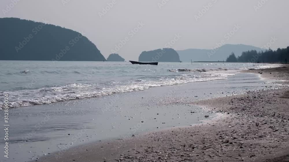 Beautiful thailand coastline on a sandy beach, waves was crashing onto the shoreline, in the morning time, beauty nature sea background. wide view of a cliff and boat in the distance Beautiful thailand coastline on a sandy beach, waves was crashing onto the shoreline, in the morning time, beauty nature sea background. wide view of a cliff and boat in the distance