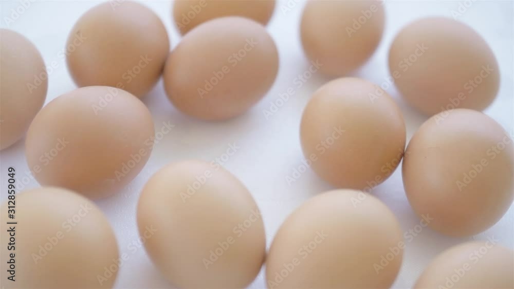 egg being taken from table full of eggs on white background where are blurred eggs egg being taken from table full of eggs on white background where are blurred eggs