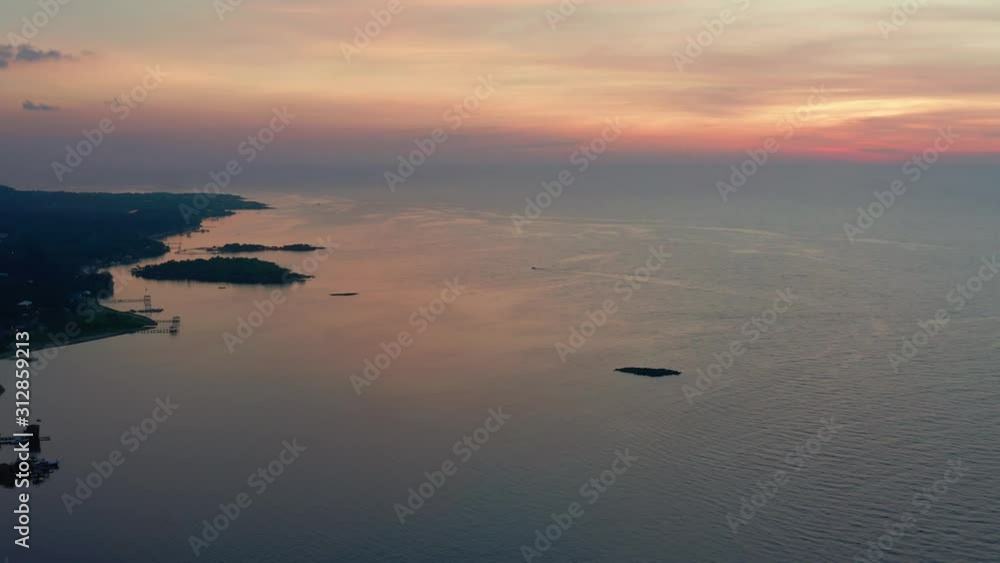 Aerial high over island and ocean into orange sunset, Roatan Aerial high over island and ocean into orange sunset, Roatan