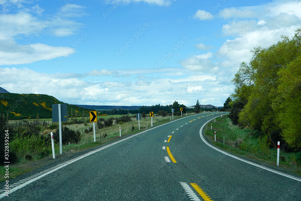 Lake, mountains, trees, sky, clouds in New Zealand.Mountain road, view from above Lake, mountains, trees, sky, clouds in New Zealand.Mountain road, view from above