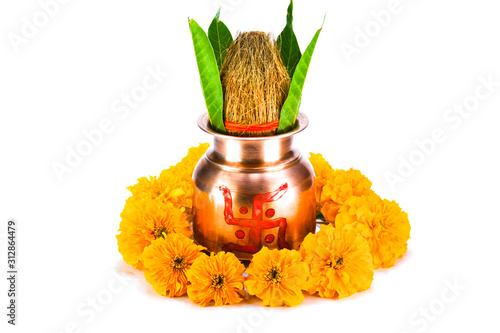 Copper kalash with coconut, mango leaf, and marigold flower isolated on white background photo