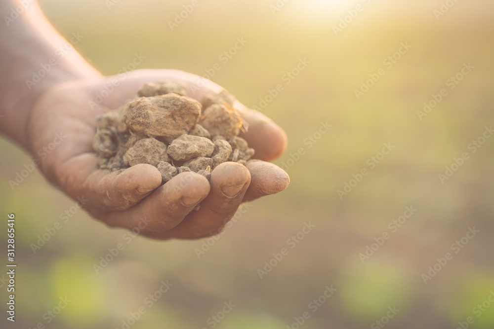 Hand holding dry soil at the field in sunrise or sunset time. Growth plant concept Hand holding dry soil at the field in sunrise or sunset time. Growth plant concept