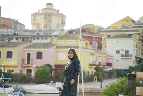 Asean young hijab girl againts colorful Town houses and buildings in the town center of Valencia around port Saplaya