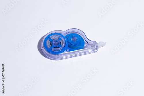 Office tape corrector in a transparent case with blue details on a white background.