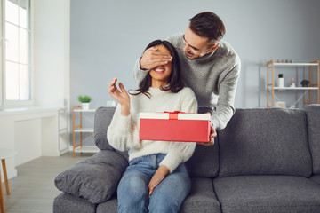 Valentine's day. A young couple gives a gift in a room