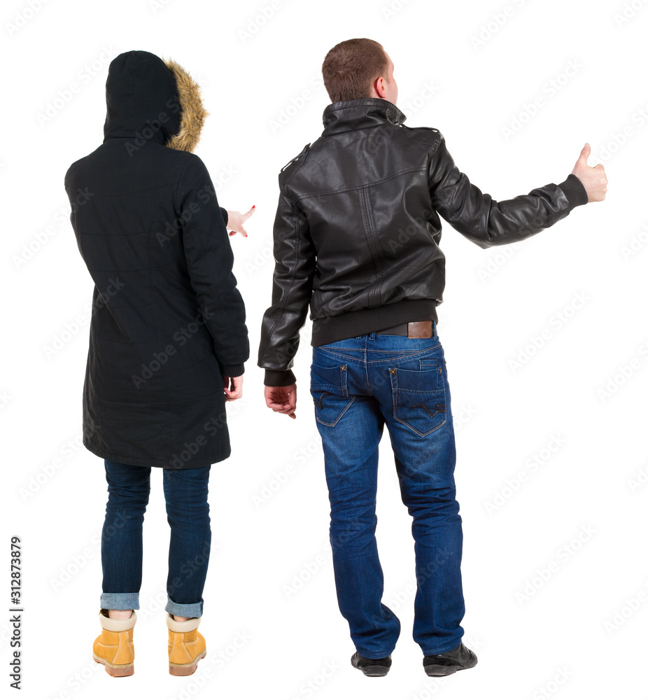 Back view of couple couple in winter jackets pointing. Back view of couple couple in winter jackets pointing.