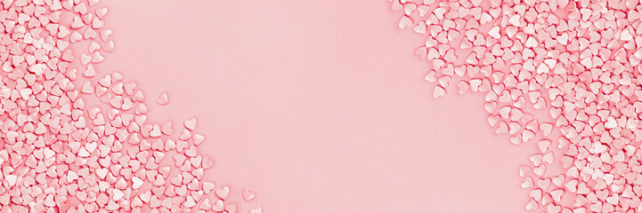 Trendy shining silver candy pink hearts background of cake sprinkles in flat lay with copy space, for feminine blogger or festive love and Valentine's Day concept. Long banner mockup