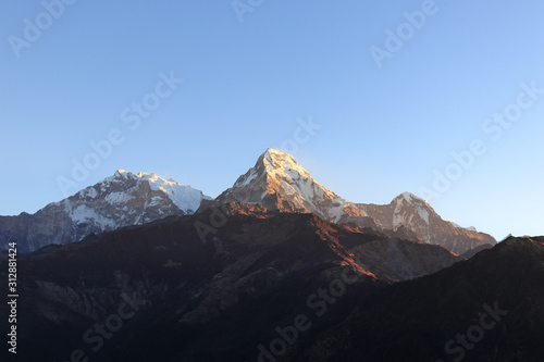 Warm pink and orange sunlight at the top of Poon Hill on Annapurna Circuit in Himalaya, Pokhara, Nepal 