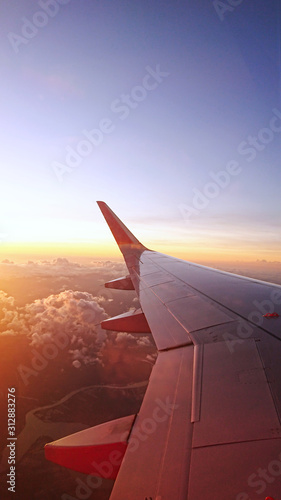  Airplane wings with background landscape sky.