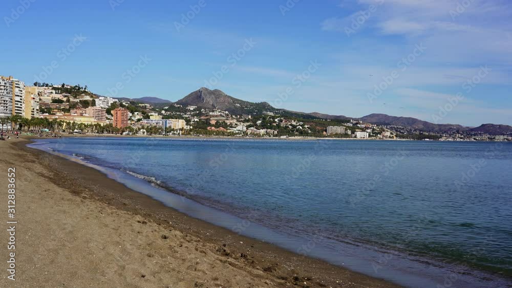 Waves gently lap the Malagueta beach of Malaga, a resort city on the famous Costa del Sol, Spain Waves gently lap the Malagueta beach of Malaga, a resort city on the famous Costa del Sol, Spain