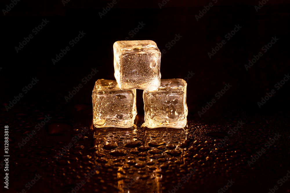 Golden ice cubes on black background. Golden ice cubes on black background.
