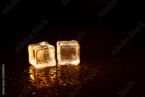 Fototapeta Naklejka Na Ścianę i Meble -  Golden ice cubes on black background.