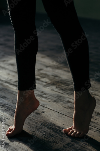 Female feet walking on warm heated floor close up view, barefoot girl legs going on hardwood living room wooden flooring at modern home house, domestic underfloor heating concept, close up rear view