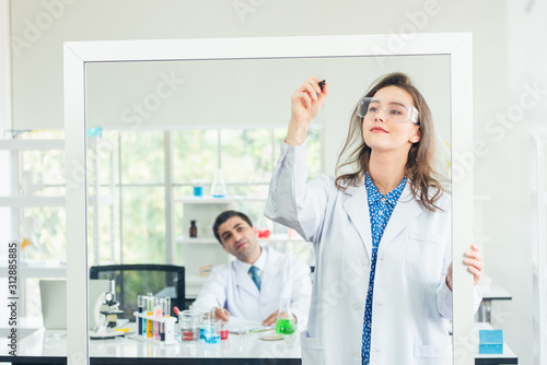 Chemistry teacher writing scientific formula of chemical on white board