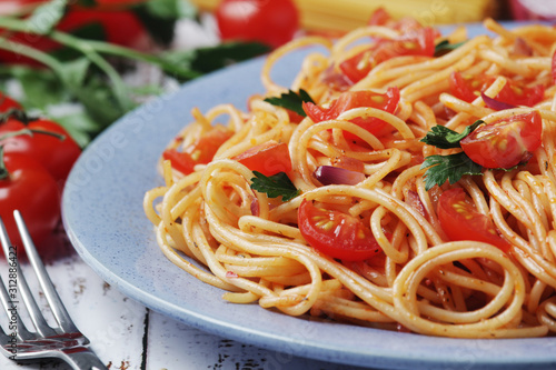 A plate with spaghetti with tomatoes 