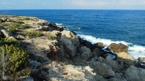 rocky shore of the blue sea, waves, white foam