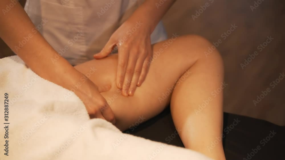 Young woman having feet massage in beauty spa salon, close up. Masseur kneads the foot and leg of a young beautiful girl. Young woman having feet massage in beauty spa salon, close up. Masseur kneads the foot and leg of a young beautiful girl.