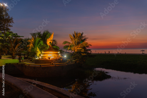 sunset behind golden dragon statue on Karon beach Phuket Thailand