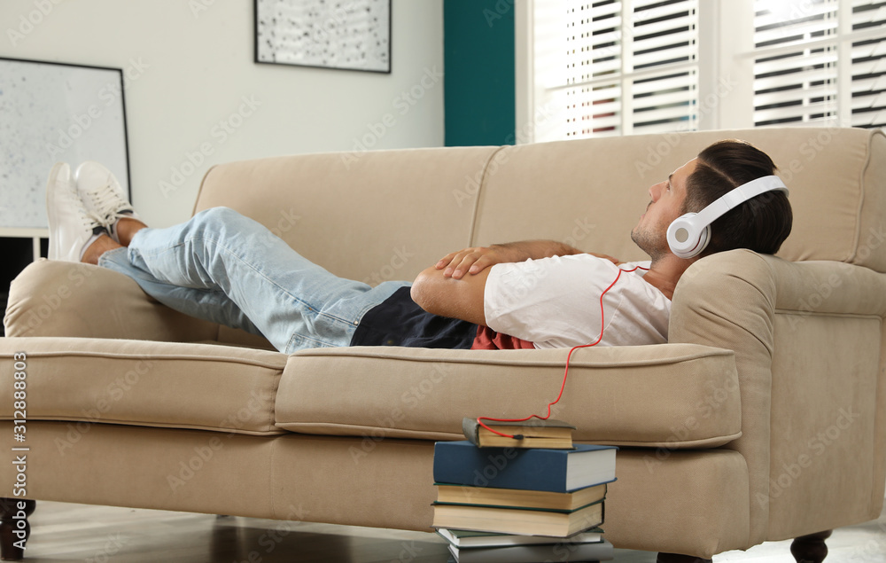 Man with headphones connected to book Man with headphones connected to book