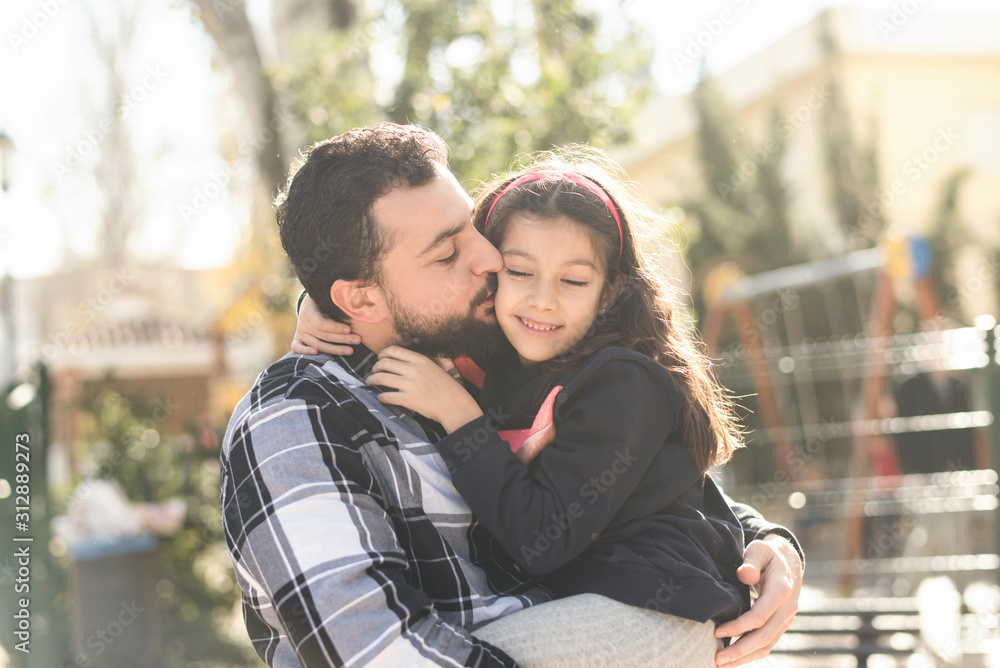 father kissing daughter in outdoors portrait father kissing daughter in outdoors portrait