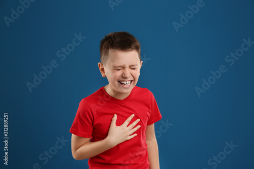 Portrait of emotional preteen boy on blue background