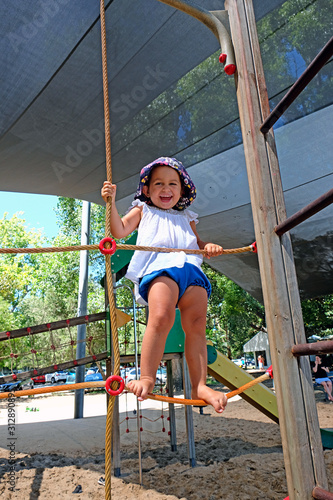 A happy laughing baby girl playing at a playground photo