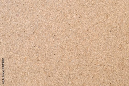 Light brown wrapping paper. Natural sheet surface, packaging background. Texture of cardboard, pasteboard, stiff paper. photo